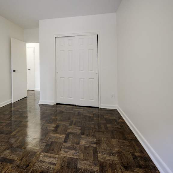 a room with a white door and a wooden floor.