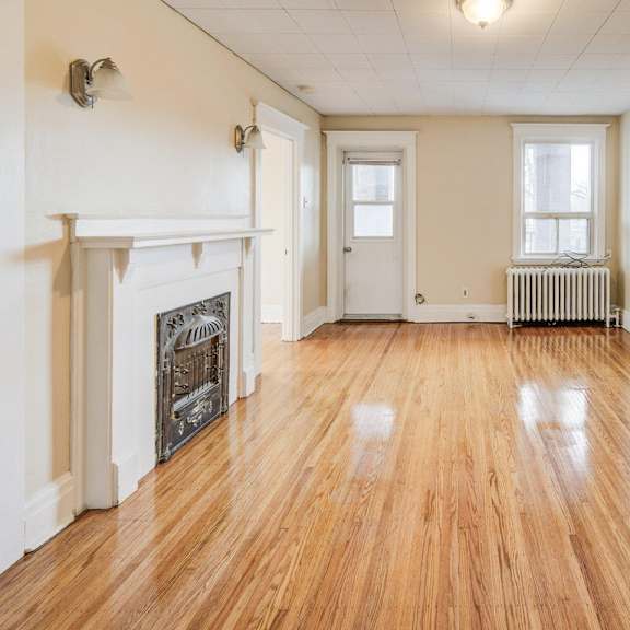 a room with wooden floors and a fireplace.