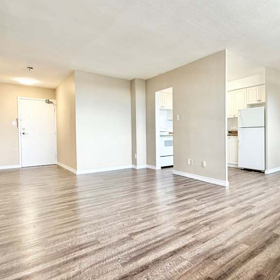 a spacious room with wood flooring and a ceiling fan.