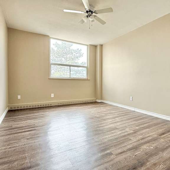 a room with a ceiling fan and a window.