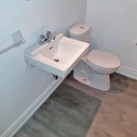 a white toilet and sink in a small bathroom.