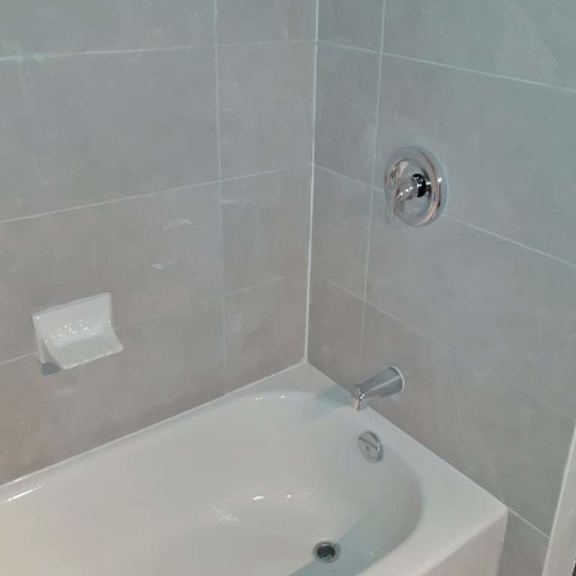 a white bathtub with a silver faucet and a silver shower head.