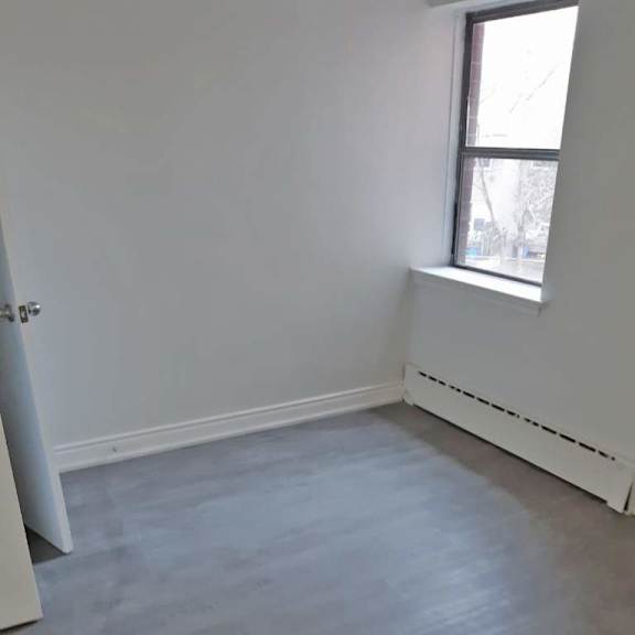 a room with a window and a white wall.