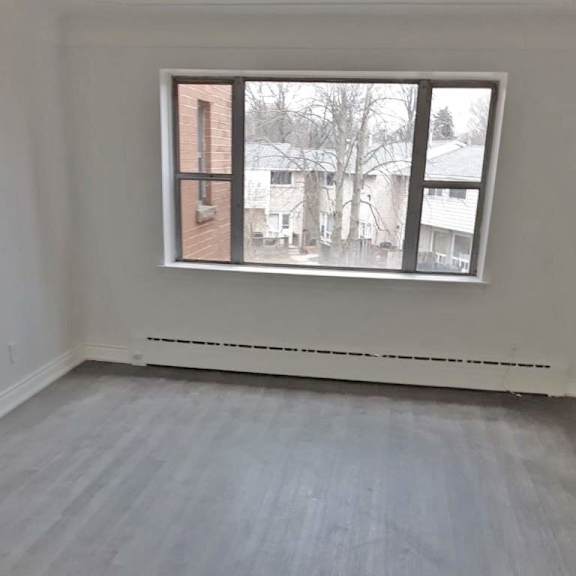 a room with a window and a white wall.