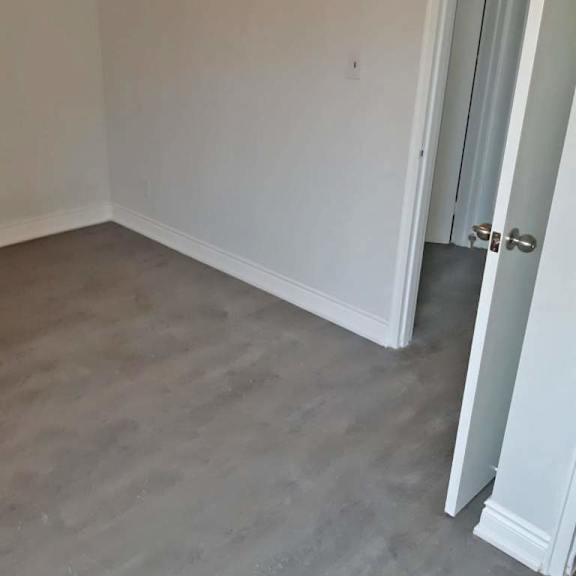 a room with a closed door and a grey floor.