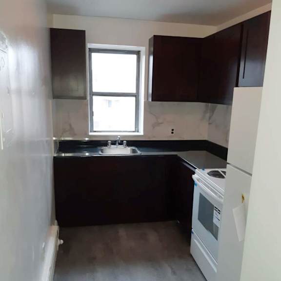 a kitchen with a white fridge and black countertops.