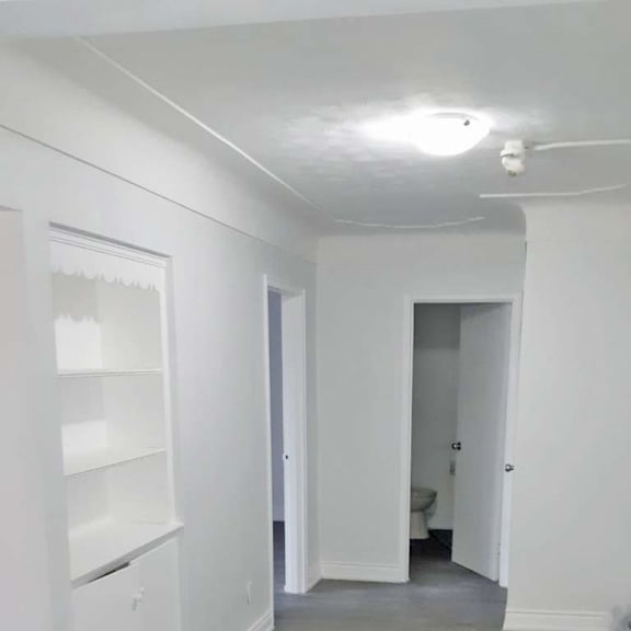 a white hallway with a door on the right.