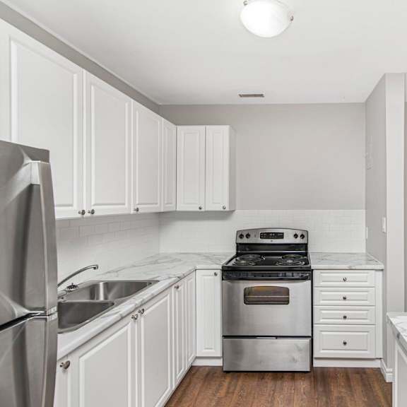 a kitchen with white cabinets and a marble countertop.