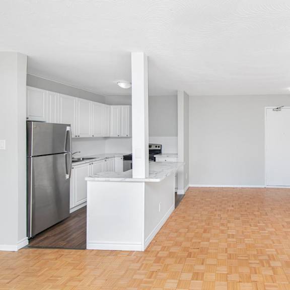 a kitchen with white cabinets and a refrigerator.