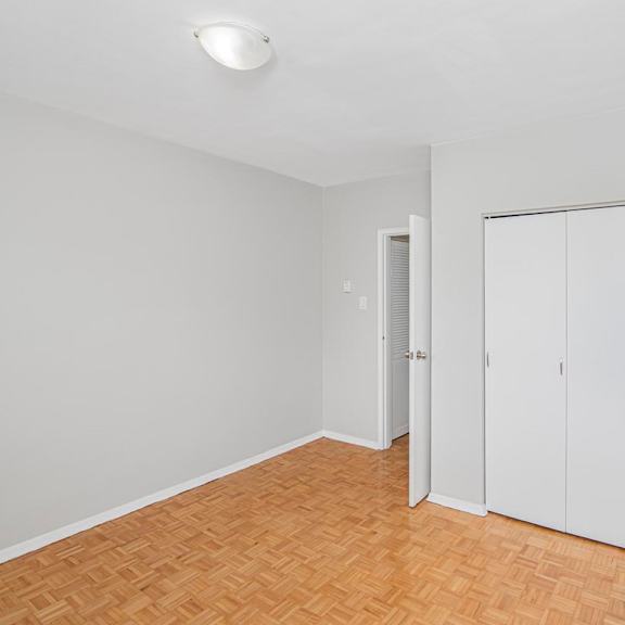 a room with a wooden floor and a white closet.