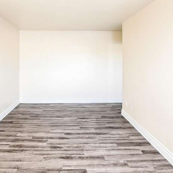 a room with wooden flooring and white walls.