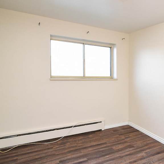 a room with a window and a radiator on the floor.