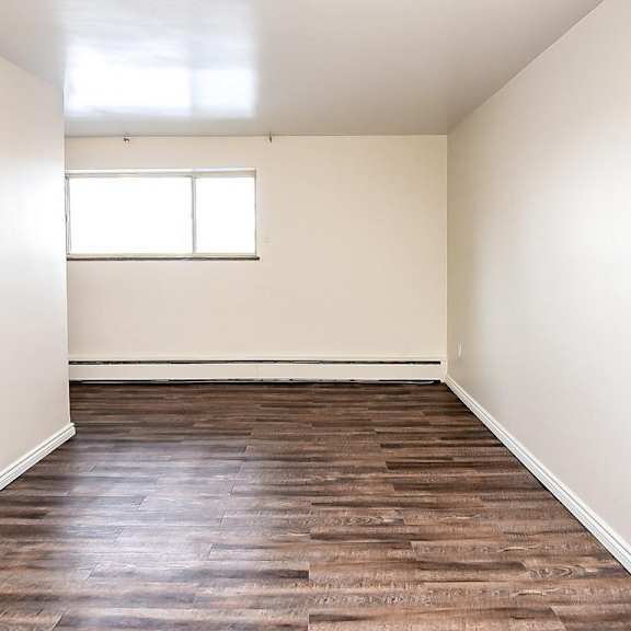 a room with wooden flooring and a window.