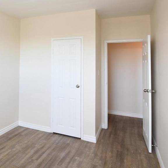 a room with a white door and a wooden floor.