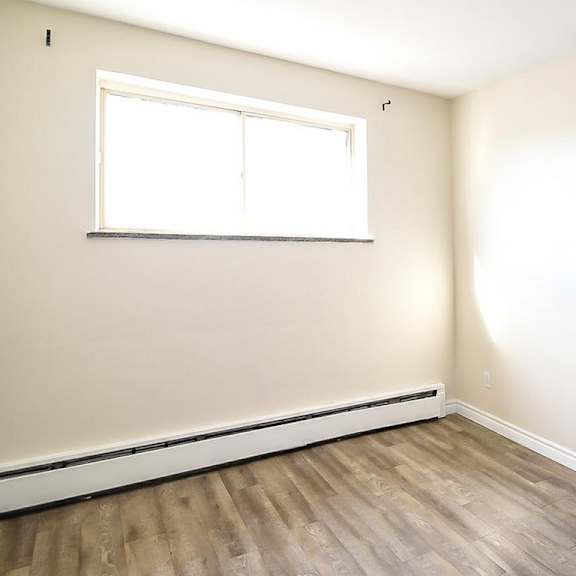 a room with a window and wooden flooring.