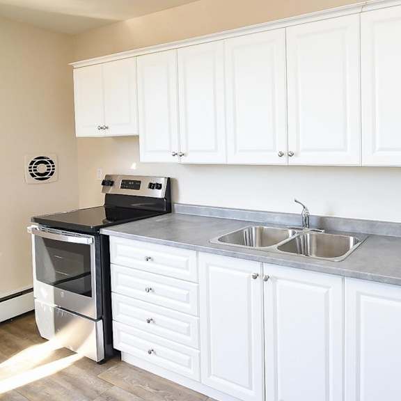 a kitchen with white cabinets and a black oven.