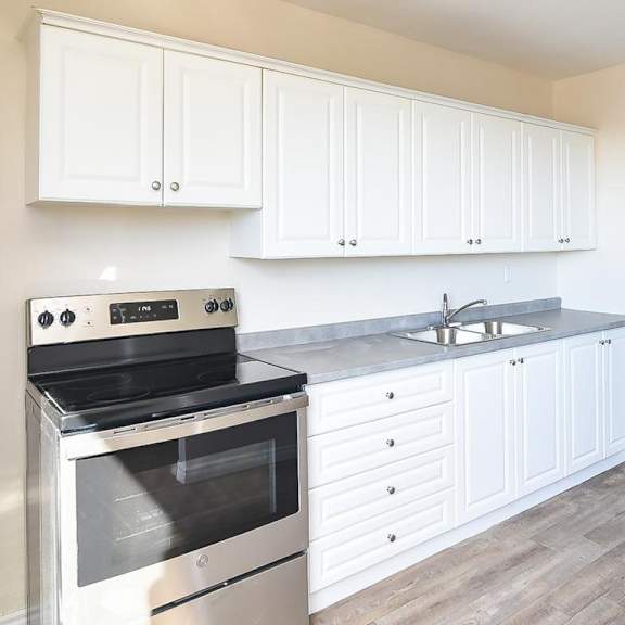 a kitchen with white cabinets and a stainless steel refrigerator.