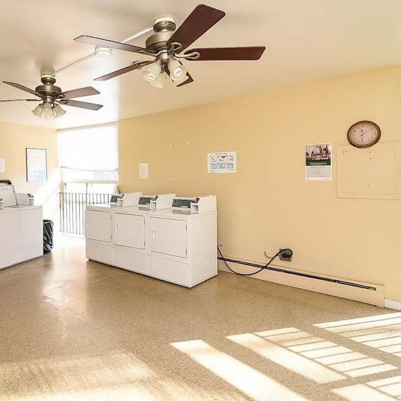a room with a ceiling fan and a clock on the wall.