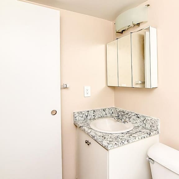 a bathroom with a toilet, sink and medicine cabinet.