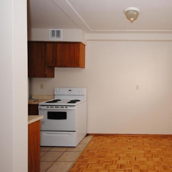 a kitchen with a white stove and wooden cabinets.