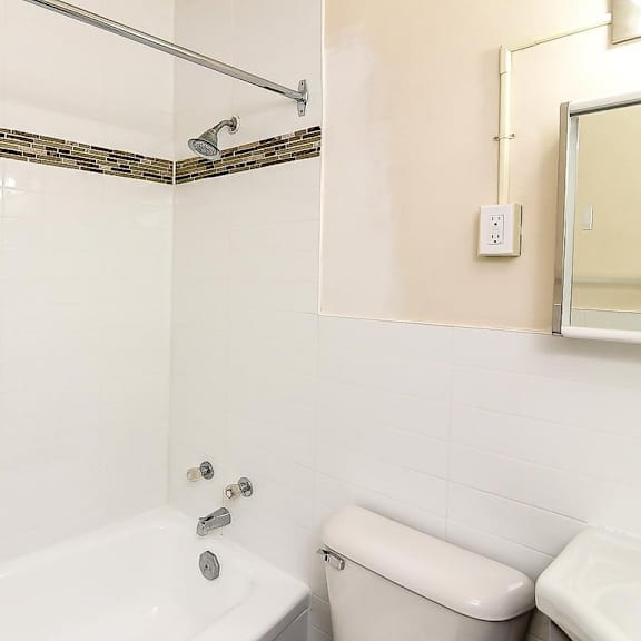 a white bathroom with a tub, toilet, and sink.