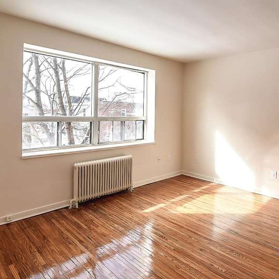 a room with a window and a radiator on the floor.