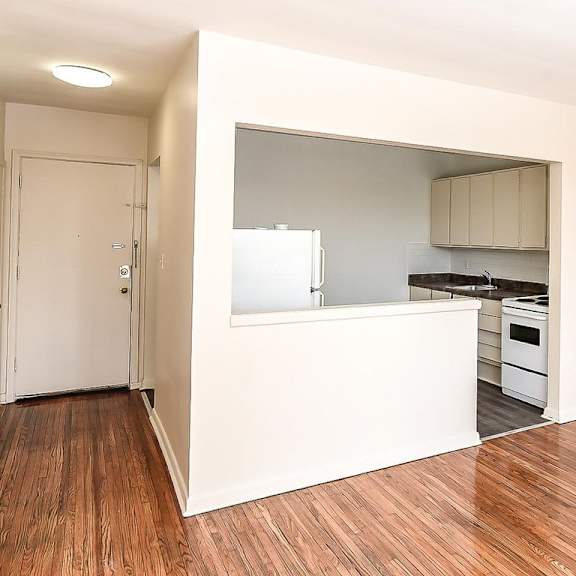 a kitchen with a white countertop and wooden floors.