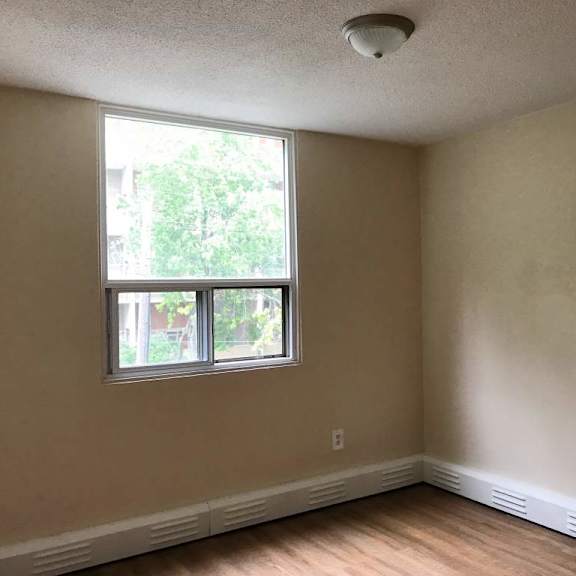 a room with a window and a smoke detector on the ceiling.
