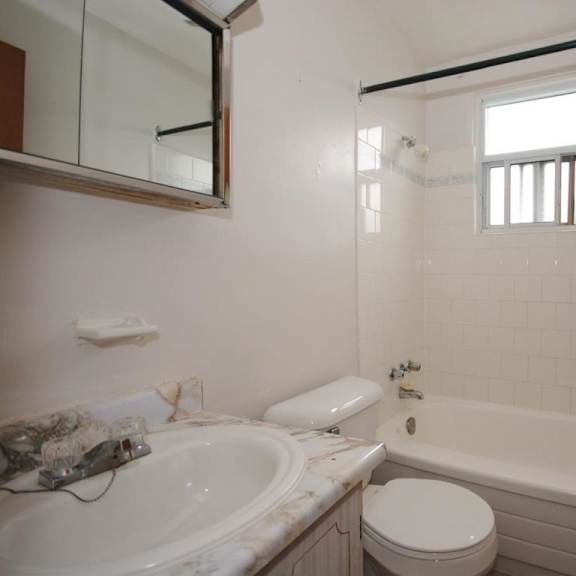 a white bathroom with a tub, toilet, and sink.