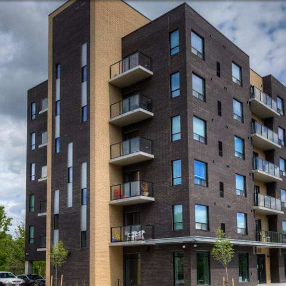 a modern apartment building with balconies and multiple windows.