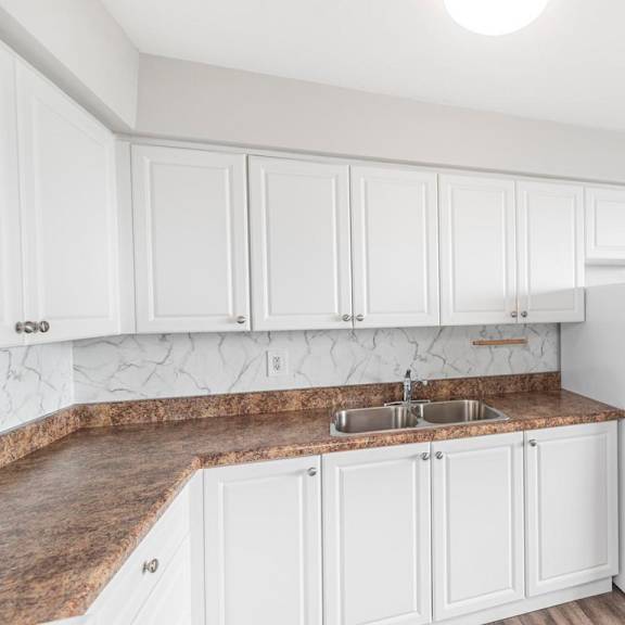 a kitchen with white cabinets and a granite countertop.