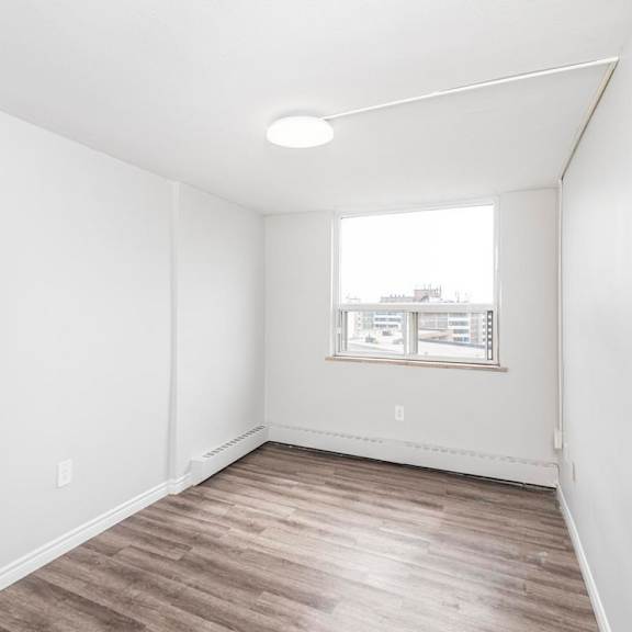 a room with a window and a wooden floor.