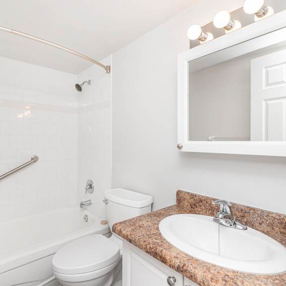 a white bathroom with a sink, toilet, and bathtub.