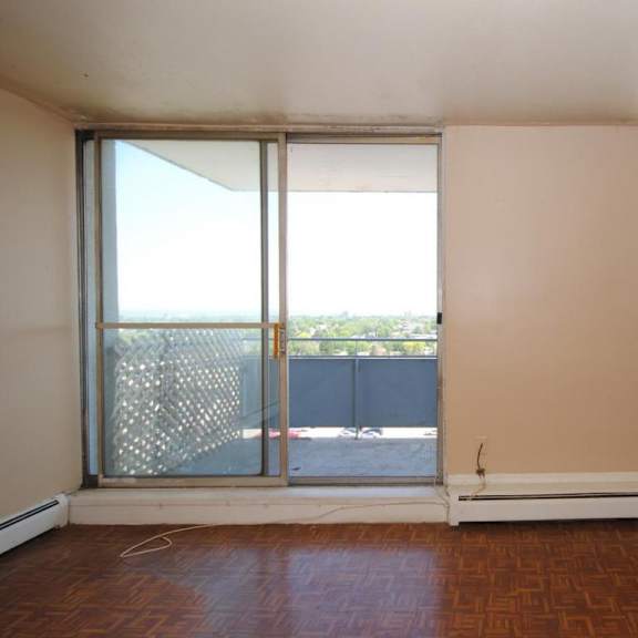a room with a sliding glass door leading to a balcony.
