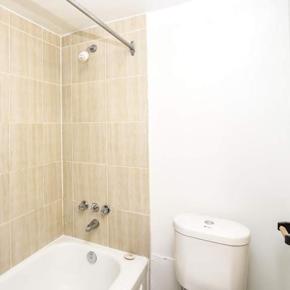 a white toilet sits next to a bathtub in a bathroom.