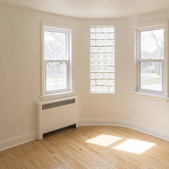 a room with two windows and a radiator on the wall.