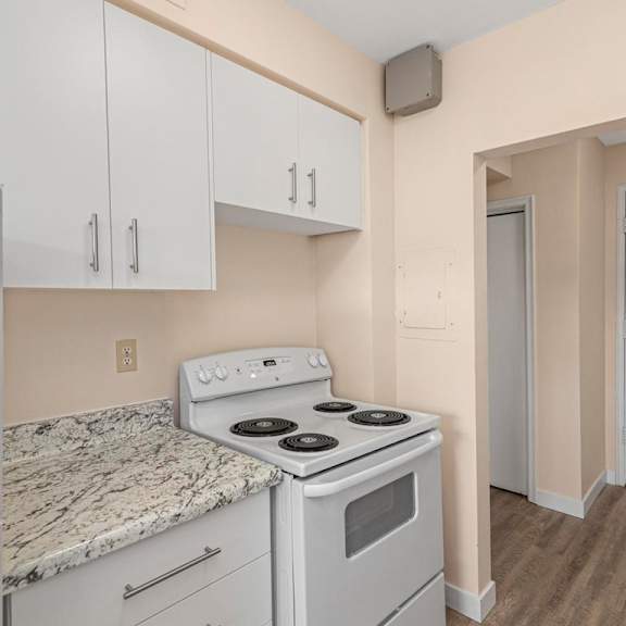 a kitchen with a white stove and cabinets.