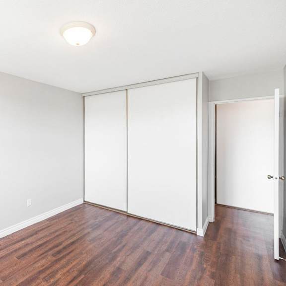 a room with a white wall and a brown floor.