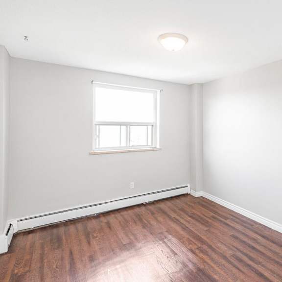 a room with a window and wooden floors.