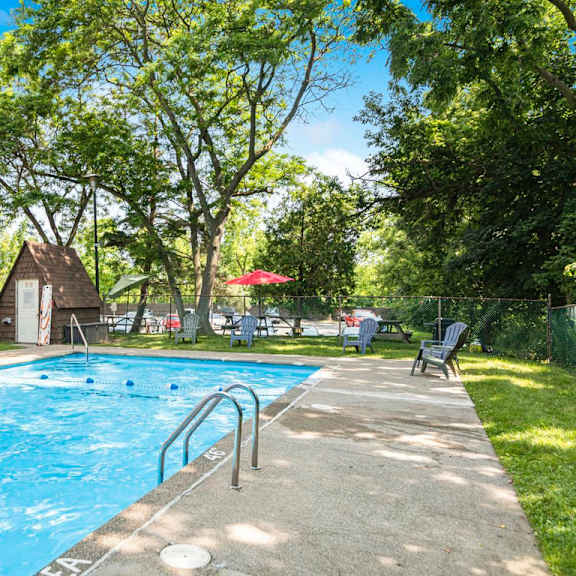 a swimming pool surrounded by trees and a grassy area.