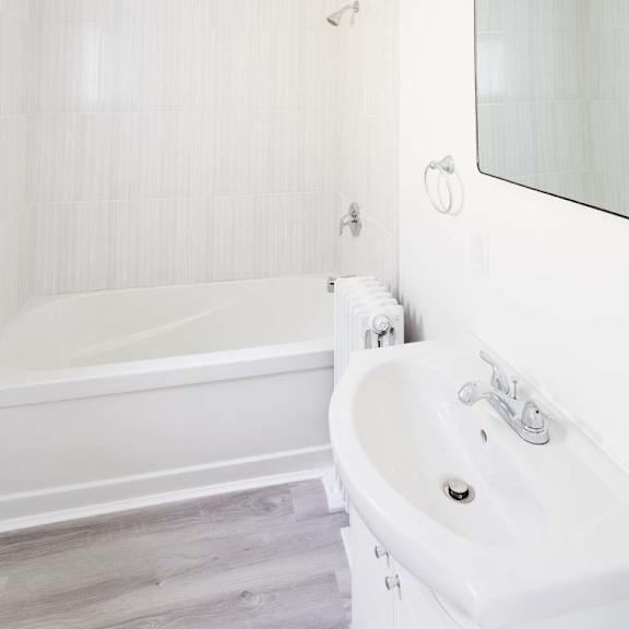 a white bathroom with a tub and sink.
