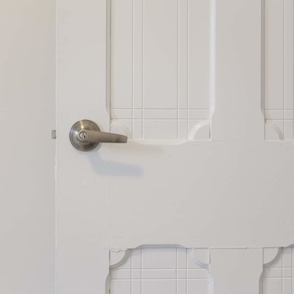a silver door handle on a white door.