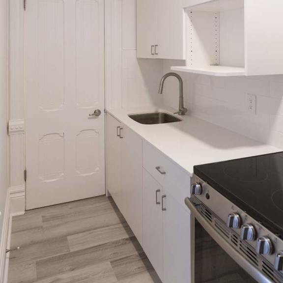 a kitchen with white cabinets and a black stove top.
