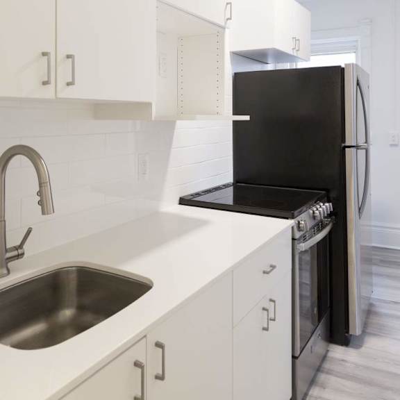 a modern kitchen with a black refrigerator and stainless steel sink.