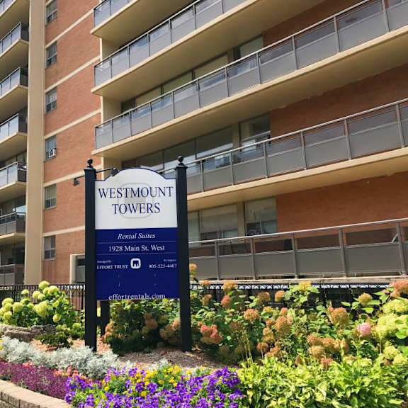 a sign for westmount towers stands in front of a building.