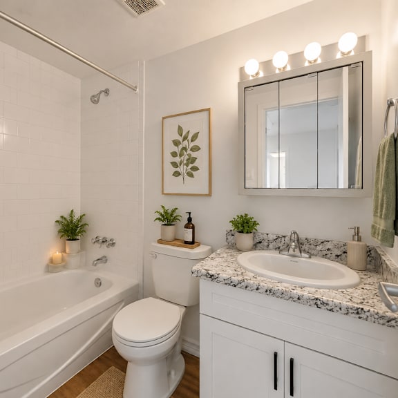 a white bathroom with a toilet, sink, and a shower.