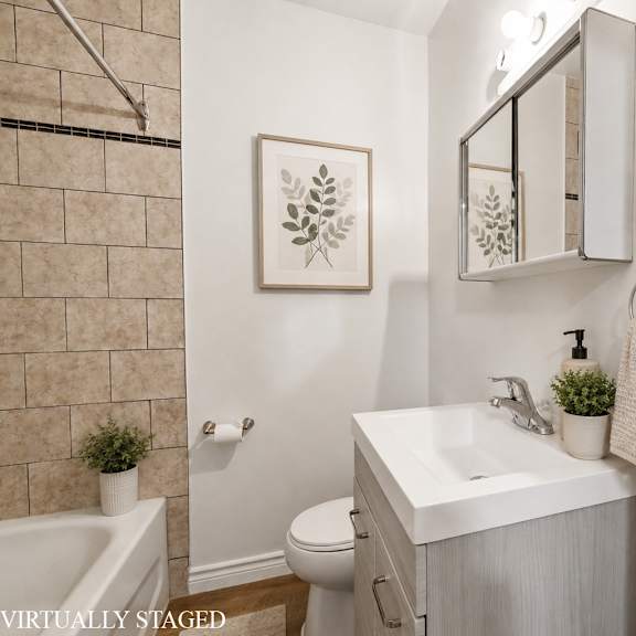 a bathroom with a white toilet, sink, and a plant.