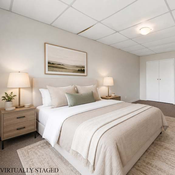 a bedroom with a large bed, two nightstands, and a painting on the wall.