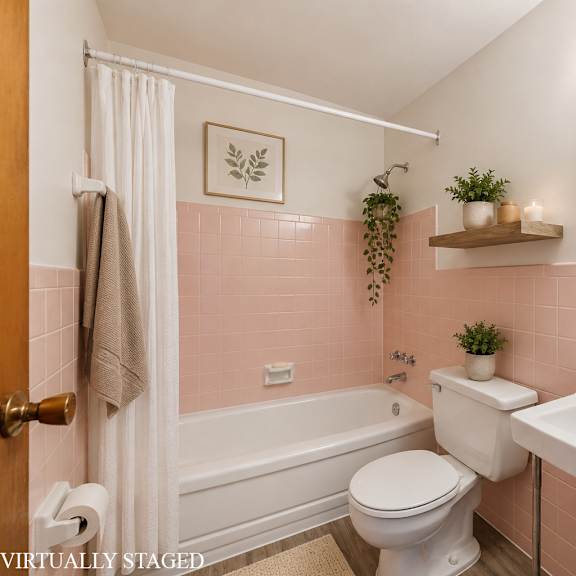 a bathroom with pink walls and a white toilet and sink.