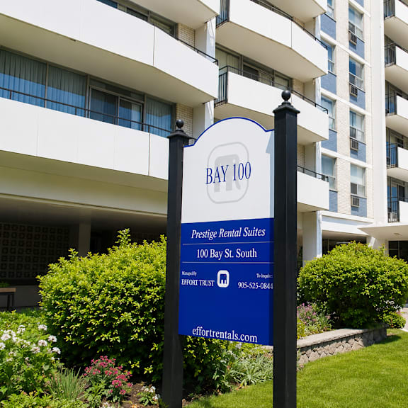 a sign for bay 100 prestige retiree sales stands in front of a building.